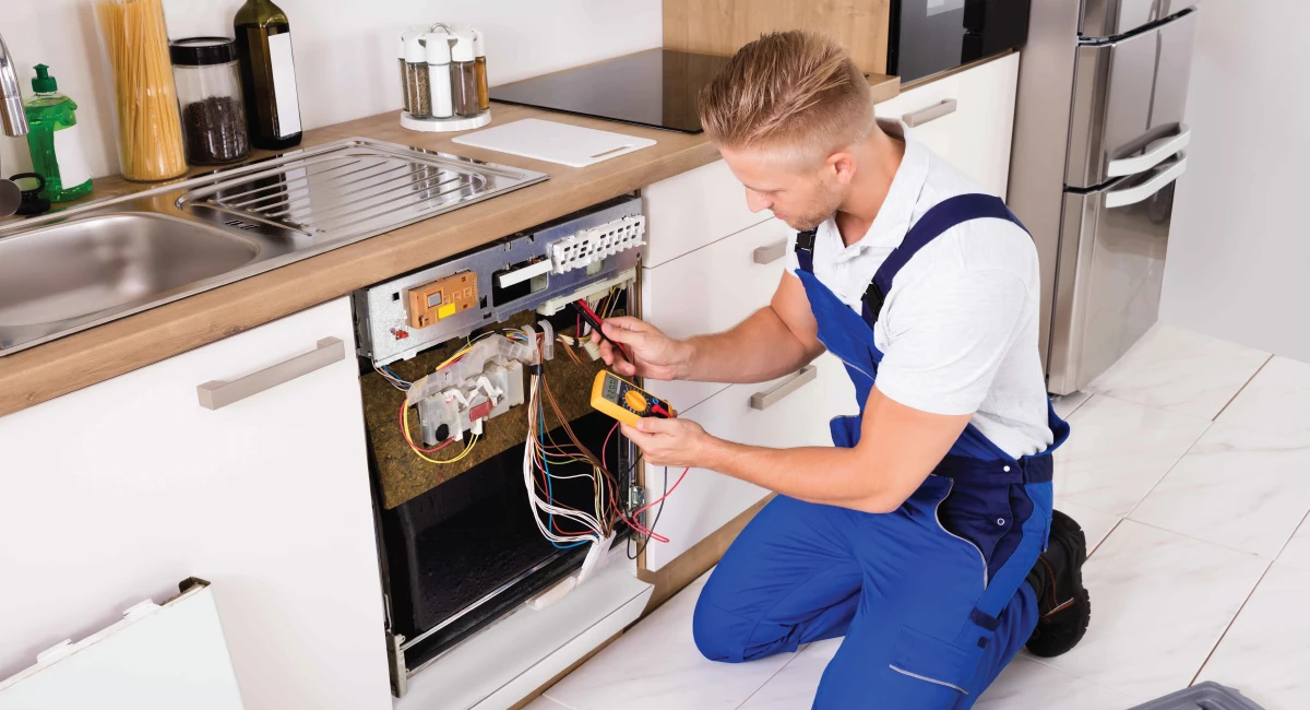 Technician checking the internal controls of a dishwasher