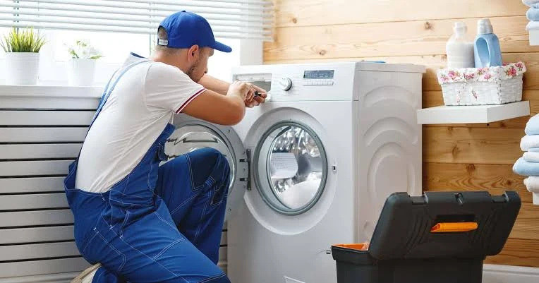 Technician inspecting the controls of a front-load washing machine