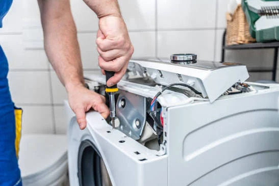 Close-up of a technician repairing the internal components of a washing machine